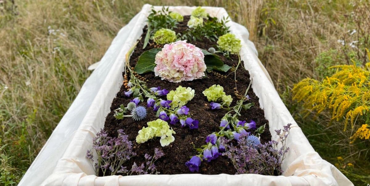 Bloemen in vruchtbare aarde, gedragen in een linnen doek in een weide.